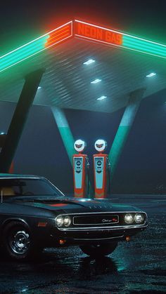 an old black car parked in front of a gas station at night with neon lights