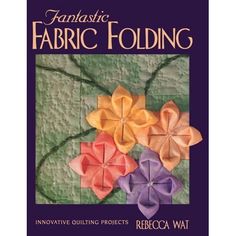 the front cover of an instruction book for fabric folding, featuring flowers on a green cloth