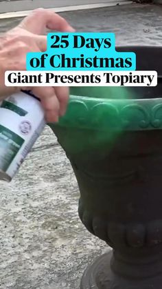 a person is spraying paint on a large green pot with the words 25 days of christmas giant presents topiary