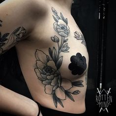 a close up of a woman's breast with flowers on it