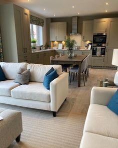 a living room filled with furniture next to a kitchen and dining area in a home