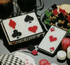 a table topped with two cakes covered in playing cards next to cups and saucers