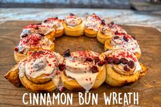 cinnamon bun wreath with white icing and cranberry toppings on a cutting board