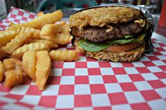 a hamburger and french fries on a checkered tablecloth