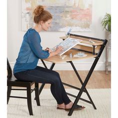 a woman sitting at a desk with a magazine