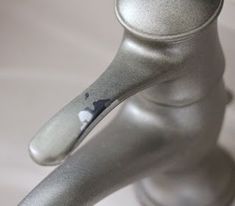 a close up of a metal object on a white table cloth with a silver handle