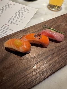 two pieces of sushi on a wooden cutting board