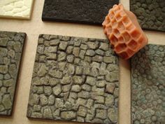 several different types of tile laid out on the floor with an orange object in between them