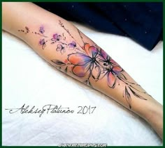 a woman's leg with flowers on it and the bottom half of her arm