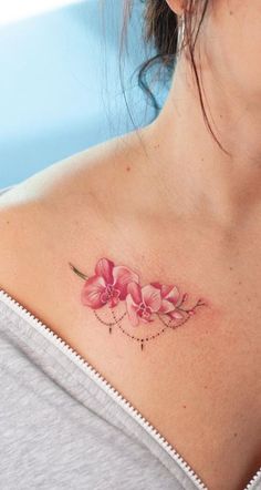 a woman with a pink flower tattoo on her chest