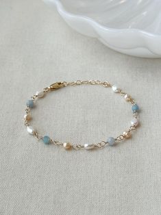 Please review the bracelet sizing guide below for the perfect fit! This dainty genuine Pearl and light blue Aquamarine gemstone bracelet is a gorgeous accents to any special occasion outfit. Each bead is hand wrapped in 14K Gold Filled or 925 Sterling Silver.  * 4mm genuine Aquamarine  * 5-7 mm pink and white Pearls * 14K Gold Filled or 925 Sterling Silver accents * 14/20 GF for authenticity * Adjustable fit: 6.75" with 1" extender chain  *Natural pearls will vary slightly in shape and color Bracelet Sizing Guide: 5-6.5 inches = xtra small 6.5-7 inches = small 7-8 inches = medium 8 inches+ = large Each Bracelet is measured held taught from tip to end. Unsure what size to choose? The best way to find the right size is to take a string (even floss) and measure your wrist, then add 1/2 to a f Occasion Outfit, Bracelet Elegant, Aquamarine Bracelet, Color Bracelet, Bracelet Wedding, Basic Jewelry, Keepsake Jewelry, Bridal Bracelet, Aquamarine Gemstone