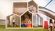 children playing in an indoor play area with slide and climbing wall at the back side