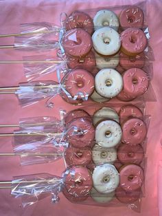 pink donuts with white frosting and sprinkles in plastic wrappers