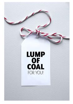 a piece of paper that says lump of coal for you hanging from a string on a wall