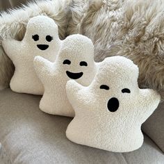 three ghost pillows sitting on top of a couch