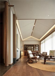 a living room filled with lots of furniture and wooden flooring next to tall windows