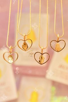 four heart shaped pendants hanging from a gold chain