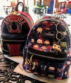 two avengers backpacks sitting on top of a table