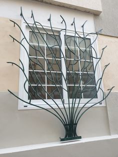 a window that has some branches on it in front of a building with white windows