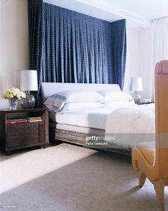 a white bed sitting next to a window in a bedroom