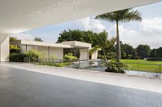 an empty room with large windows and palm trees in the foreground, overlooking a golf course