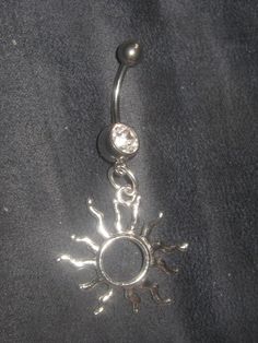 a sun and moon belly ring is shown on a black sheeted background with silver beads