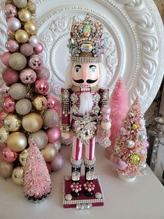 a nutcracker standing in front of a christmas tree with ornaments on the table