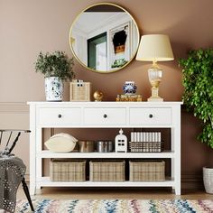 a white shelf with baskets under a round mirror on the wall next to a lamp