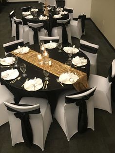 a banquet table set up with black and white linens, gold sequined runner