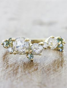 three stone diamond ring sitting on top of a piece of wood