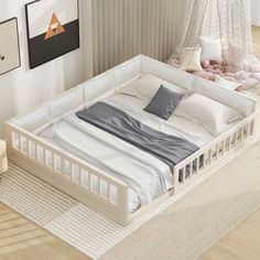 a white bed sitting on top of a wooden floor