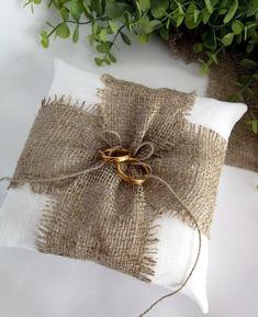 two gold wedding rings tied to a burluck pillow