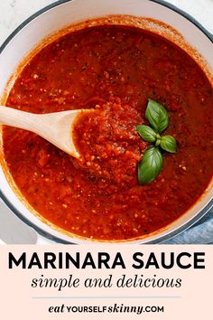 marinara sauce in a white bowl with a wooden spoon and basil leaves on top