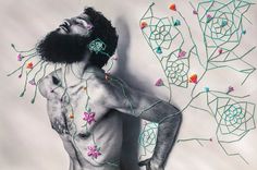 a man with tattoos on his chest standing in front of an artistic wallpaper design