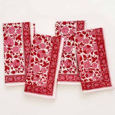 four red and white napkins sitting on top of each other in front of a white background