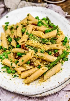 pasta with peas and parmesan cheese on a white plate, ready to be eaten