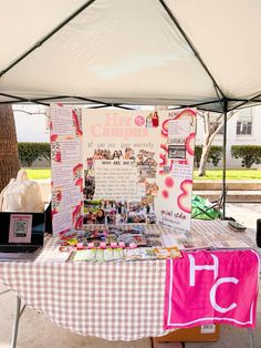 a table with a checkered cloth on it under a white and pink tented area