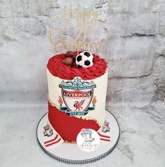 a soccer themed birthday cake is displayed on a white plate with a red and gold frosting