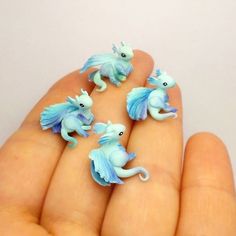 five tiny blue and white seahorse figurines in hand