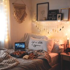 a bed room with a neatly made bed and some pictures on the wall above it