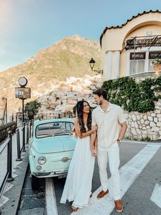 a man and woman standing in front of a car