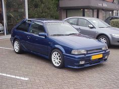 a blue car parked in front of a building