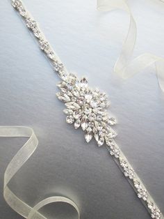 "This sparkly skinny bridal belt is made with top quality Swarovski crystals beaded on 3/8\" wide organza ribbon. The crystal part of the belt measures 24\" and 1 3/4\" wide in the center. The entire sash measures 150\" long. Available in gold or silver finish. It can be made with your choice of organza, satin or grosgrain ribbon." Party Crystal Bridal Accessories With Sashes, Crystal Bridal Belt With Sashes For Party, Formal Bridal Belt With Crystal Sashes, Formal Crystal Bridal Belt With Sashes, Elegant Adjustable Bridal Belt, Glamorous Wedding Bridal Belt With Crystals, Adjustable Bridal Belt With Sashes For Party, Adjustable Sashes Bridal Belt For Party, Formal Adjustable Bridal Belt With Sashes