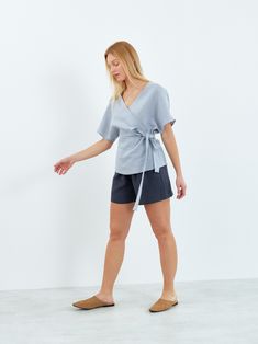 "EVIE is a kimono inspired linen wrap top. DETAILS - Short sleeve design - Side tie closure - V neckline - 100% lightweight European linen fabric - Cut and sewn to order just for you in our studio COLOR - Bluestone, you can also choose other colors above - Fabric samples are available here https://www.etsy.com/listing/586569696/linen-fabric-samples SIZING & FIT - Relaxed, loose fit - Model is 5'8\" / 173cm and wearing a size S CARE FOR LINEN - Machine wash up to 30ºC/86ºF gentle cycle - Lay flat to dry or tumble dry low - Warm iron if needed - Do not bleach SIZE GUIDE Size conversion guide Size XS (US 0-2, IT 36-38, UK 4-6, Japan 3-5, France 32-34) Size S (US 4-6, IT 40-42, UK 8-10, Japan 7-9, France 36-38) Size M (US 8-10, IT 44-46, UK 12-14, Japan 11-13, France 40-42) Size L (US 12-14, I Linen Wrap Top, Kimono Wrap Dress, Linen Wrap Dress, Studio Color, Kimono Wrap, Linen Clothing, European Linens, Linen Top, Linen Clothes