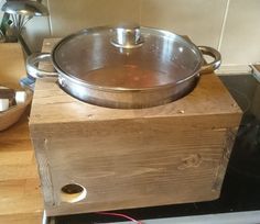 a large metal pot sitting on top of a wooden box