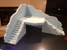 a paper mache model of a brick wall with steps leading up to the top