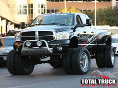 a large black truck parked in front of a building