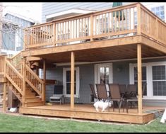 a dog is standing on the back deck of a house with stairs leading up to it