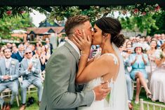 a bride and groom kissing in front of an audience