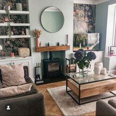 a living room filled with furniture and a fire place under a mirror on the wall